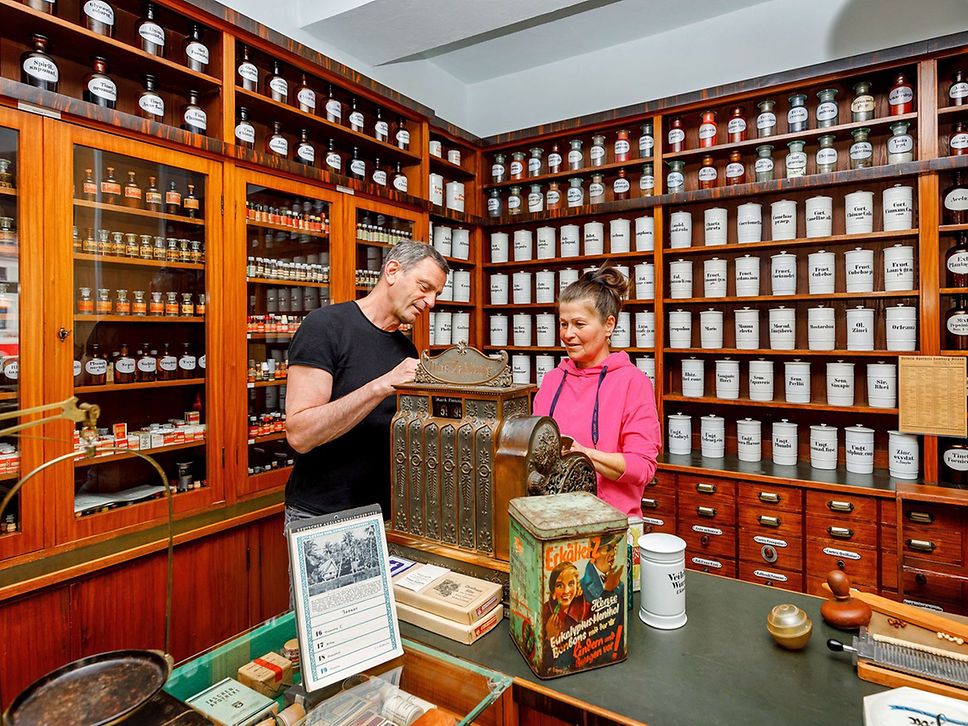 Ein Mann und eine Frau schauen Exponate im Brandenburgischen Apothekenmuseum an.