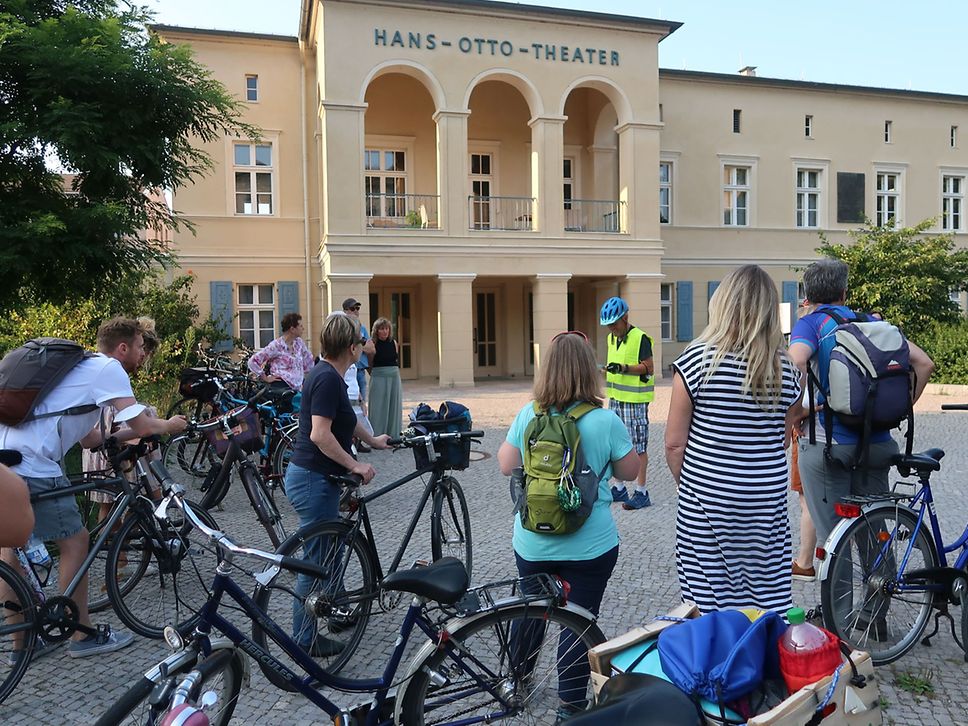 Eine Gruppe Radfahrer:innen steht vor dem Gebäude des alten Hans-Otto-Theaters in Potsdam.