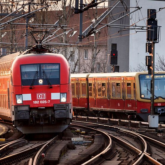 Ein Regionalzug und eine S-Bahn auf Schienen, von vorne zu sehen.