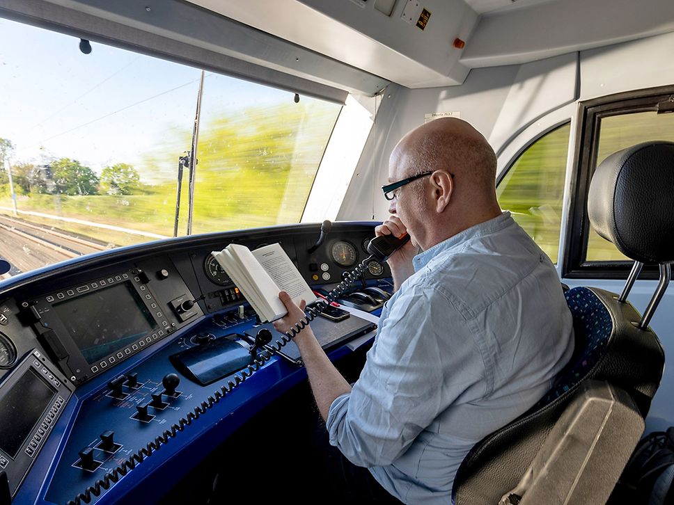 Horst Evers sitzt im Führerstand eines Zuges und liest über die Sprechanlage aus seinem Buch.