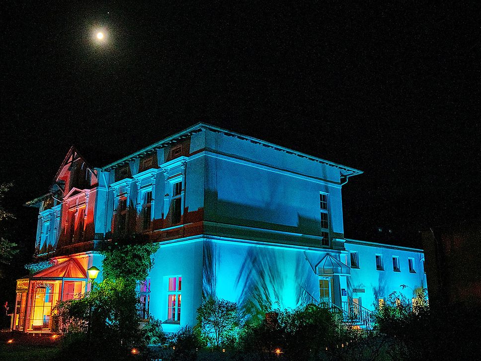Ein bunt beleuchtetes Haus in der Nacht.