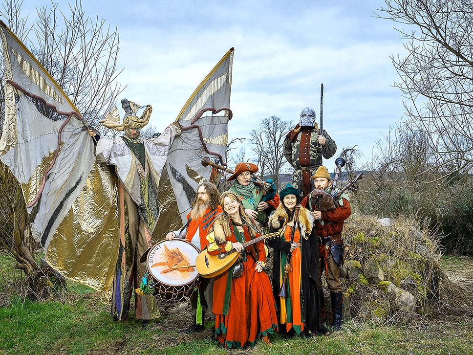 Foto einer mittelalterlichen Musikgruppe in mittelalterlichen Kostümen und mit Instrumenten.