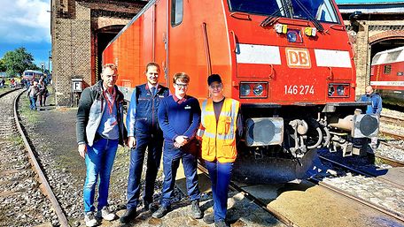 Mitarbeitende von DB Regio Nordost stehen vor einer roten Lok.