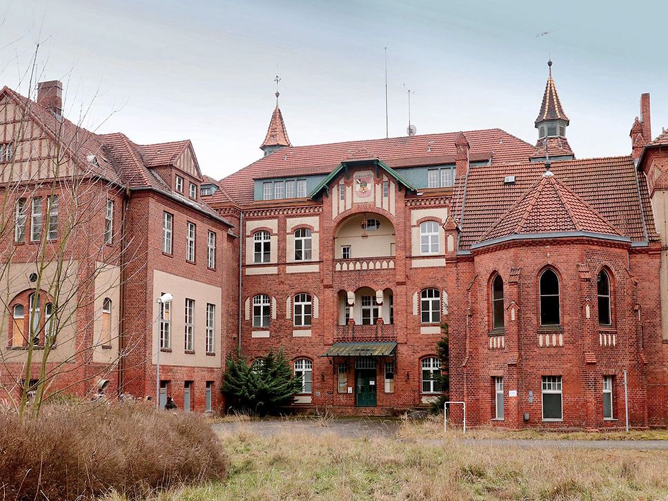 Aufnahme eines roten Backsteingebäudes mit vielen Fenstern.