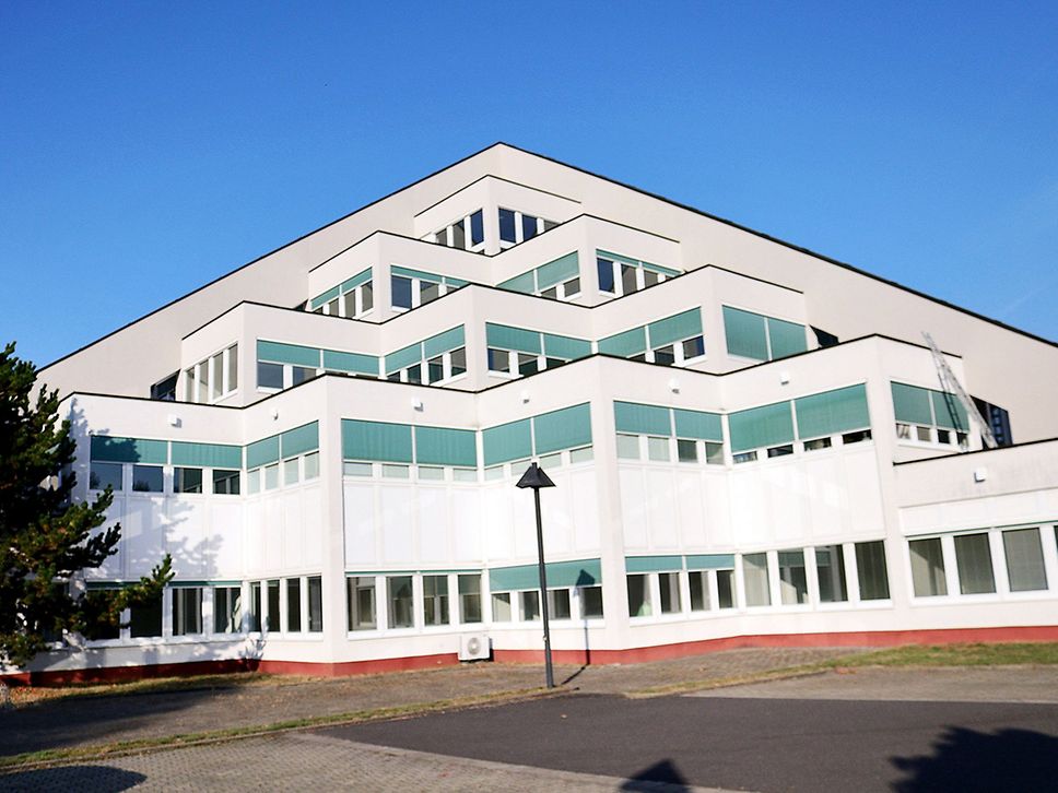 Aufnahme eines weißen Gebäudes, das an eine Pyramide erinnert.