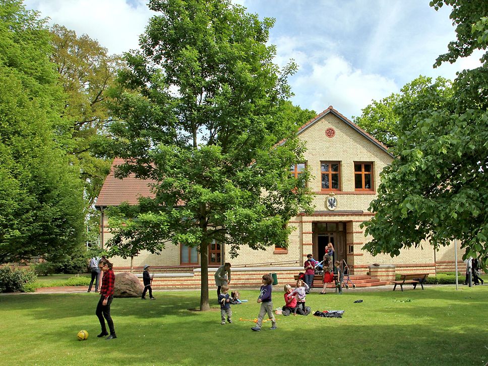 Außenansicht des Brandenburg-Preußen Museums mit Besucher:innen auf der Grünfläche vor dem Haus.