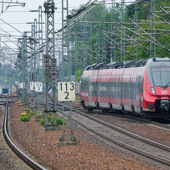 Ein roter Regionalexpress fährt auf freier Strecke.