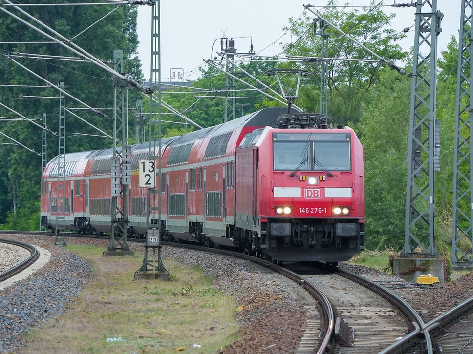 Roter Regionalzug auf freier Strecke.