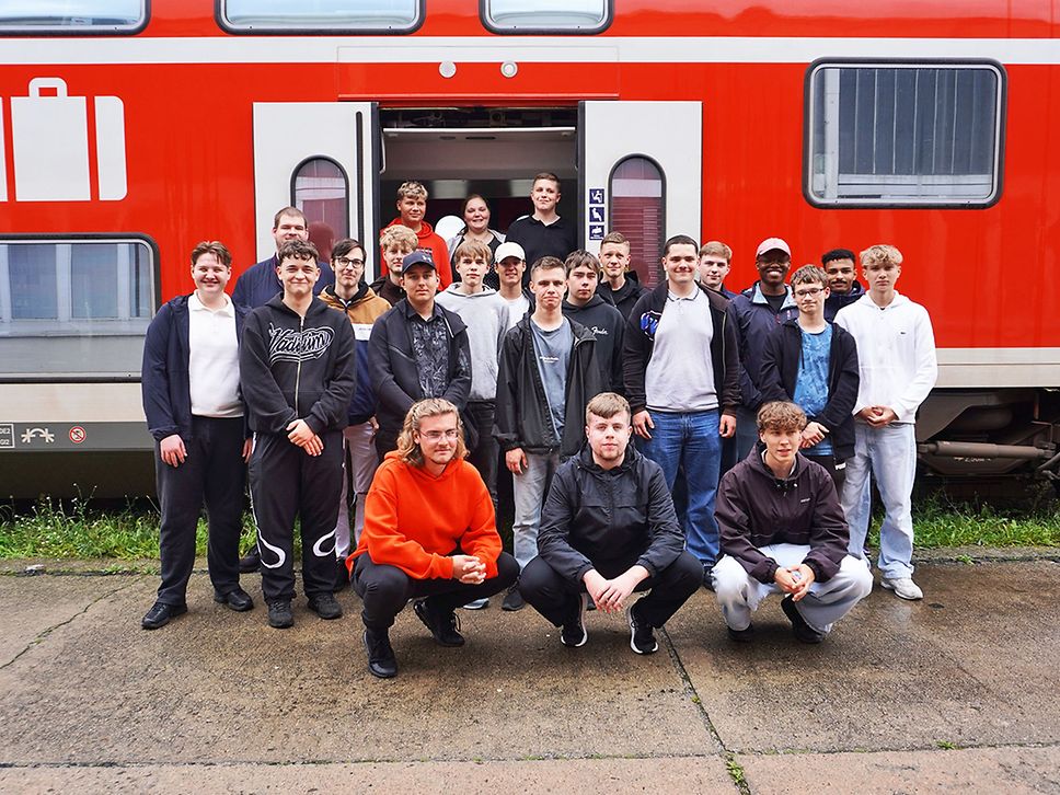 Gruppenfoto vor einem roten Regionalzug.