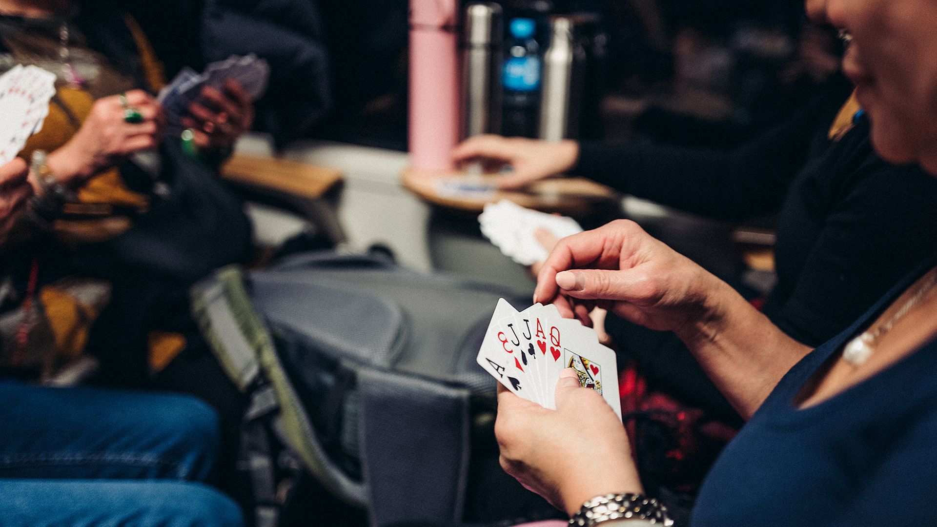 4 Menschen spielen Karten in einem Abteil des Kulturzugs