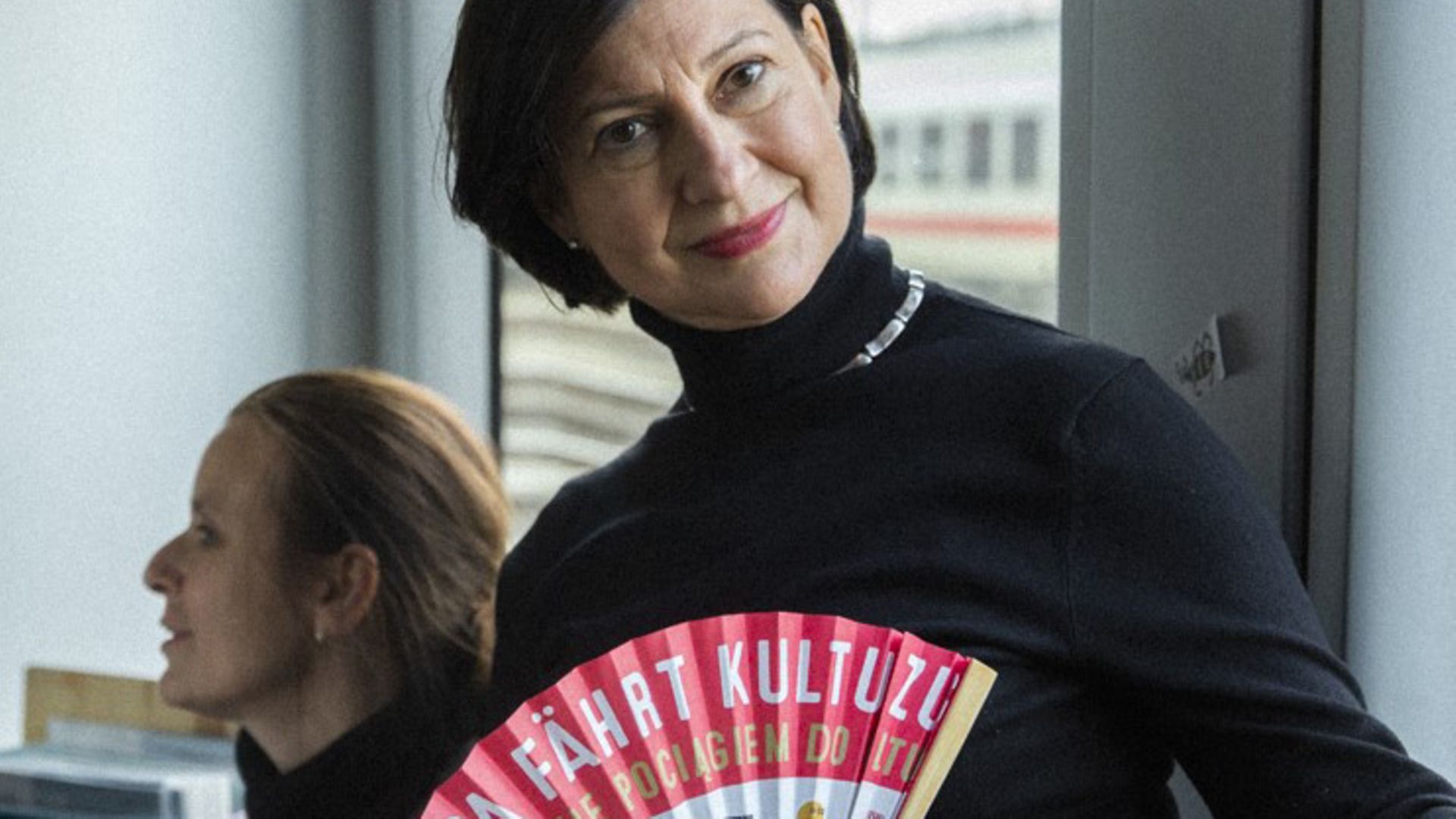 Eine Initiatorin des Kulturzugs präsentiert einen bedruckten Fächer