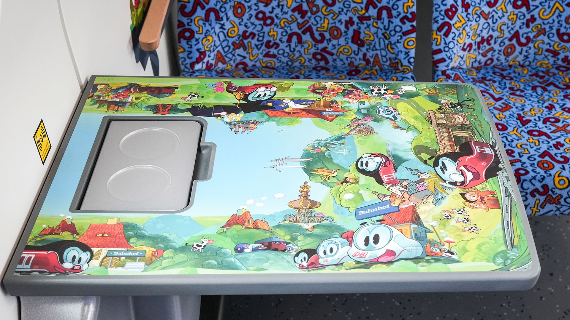 Ein Kindertisch im Zug. Der Tisch zeigt verschiedene Darstellungen des kleinen ICEs