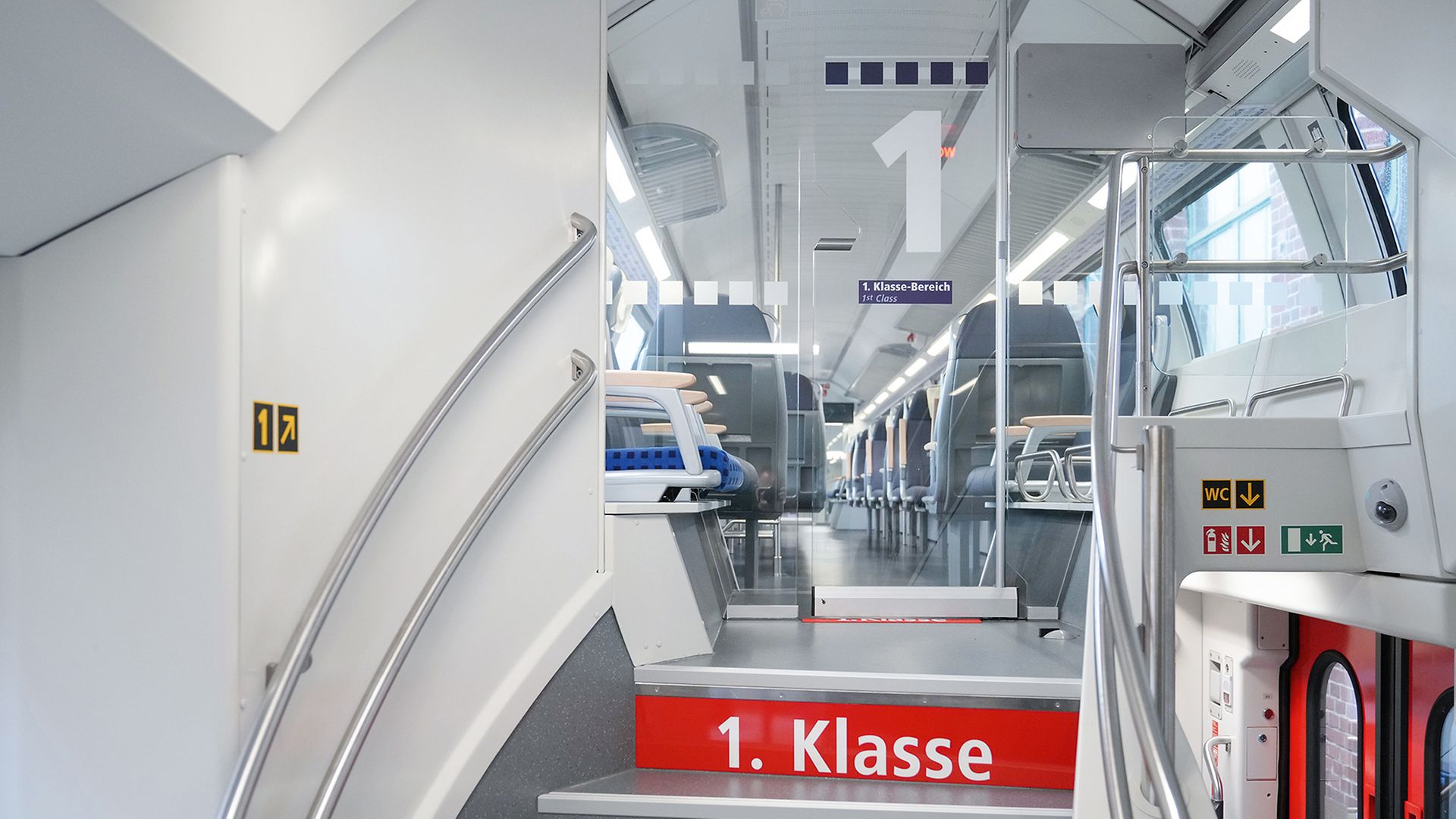 Treppenaufgang zur 1. Klasse im Doppelstockwagen, auf einem Absatz steht weiß auf rot "1. Klasse"