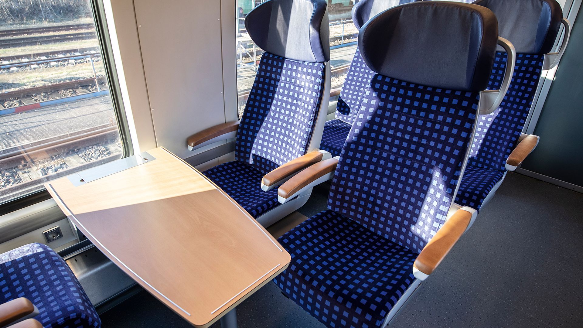 Dunkelblaue Sitzgruppe mit Tisch in der Mitte im Talent-2-Fahrzeug