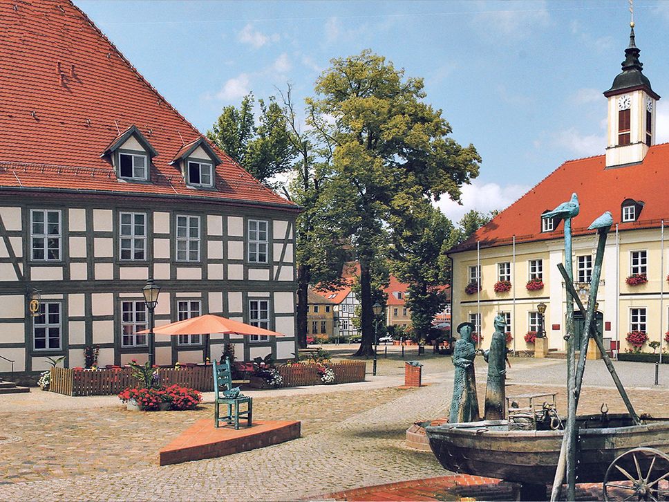 Blick auf das historische Rathaus in Angermünde, davor der Brunnen in Form eines Boots.