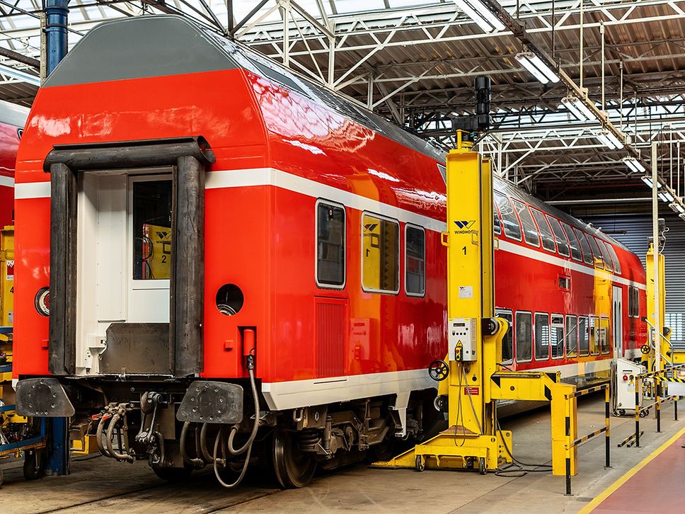 Ein roter Doppelstockzug steht in einer Werkstatt.