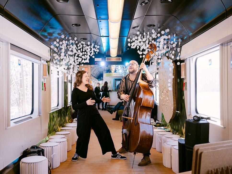 Eine Musikerin und ein Musiker mit Kontrabass im Kulturzug nach Warschau