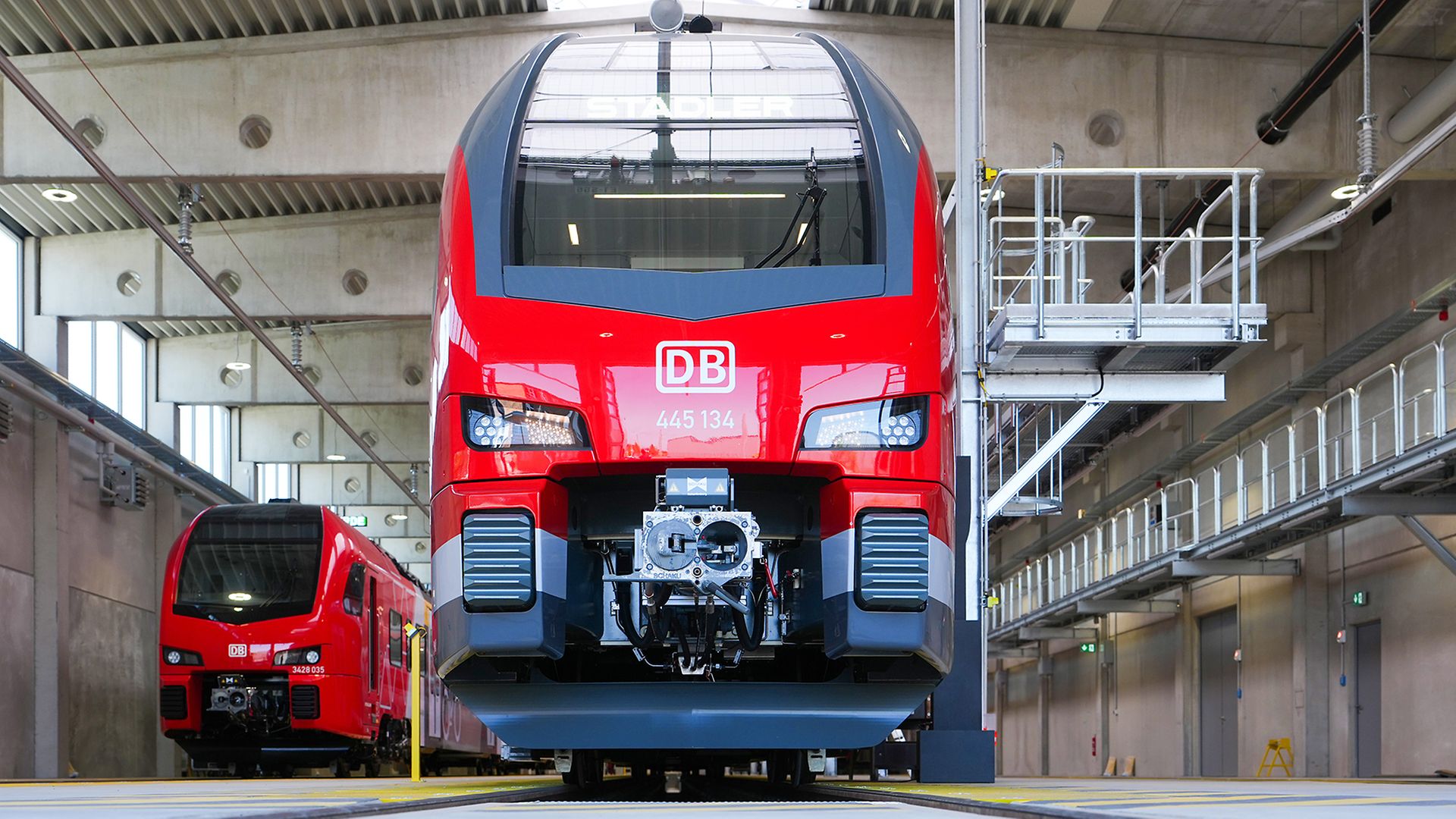 Frontansicht eines roten Doppelstock-Zuges mit prominentem DB-Logo in einer Werkstatt