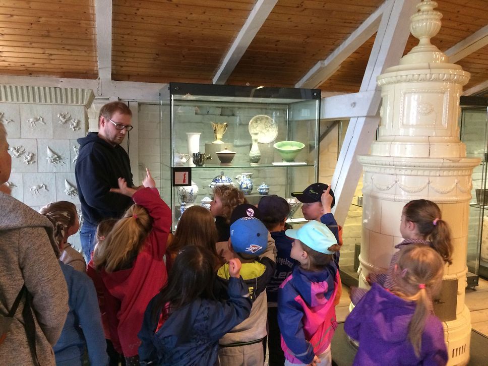 Eine Kindergruppe steht vor einer Vitrine im Museum.