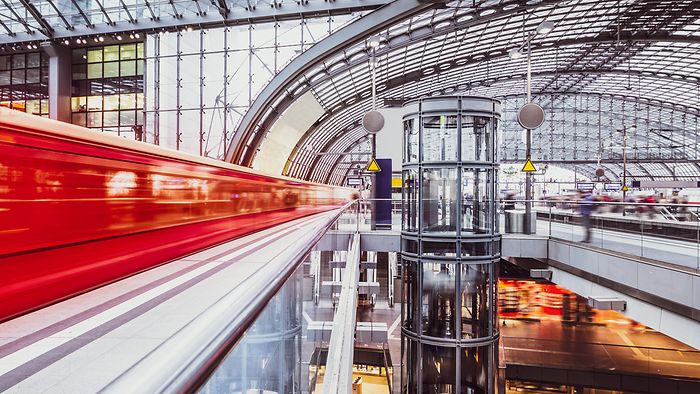 Regionalzug fährt schnell in den modernen Berliner Hauptbahnhof ein.