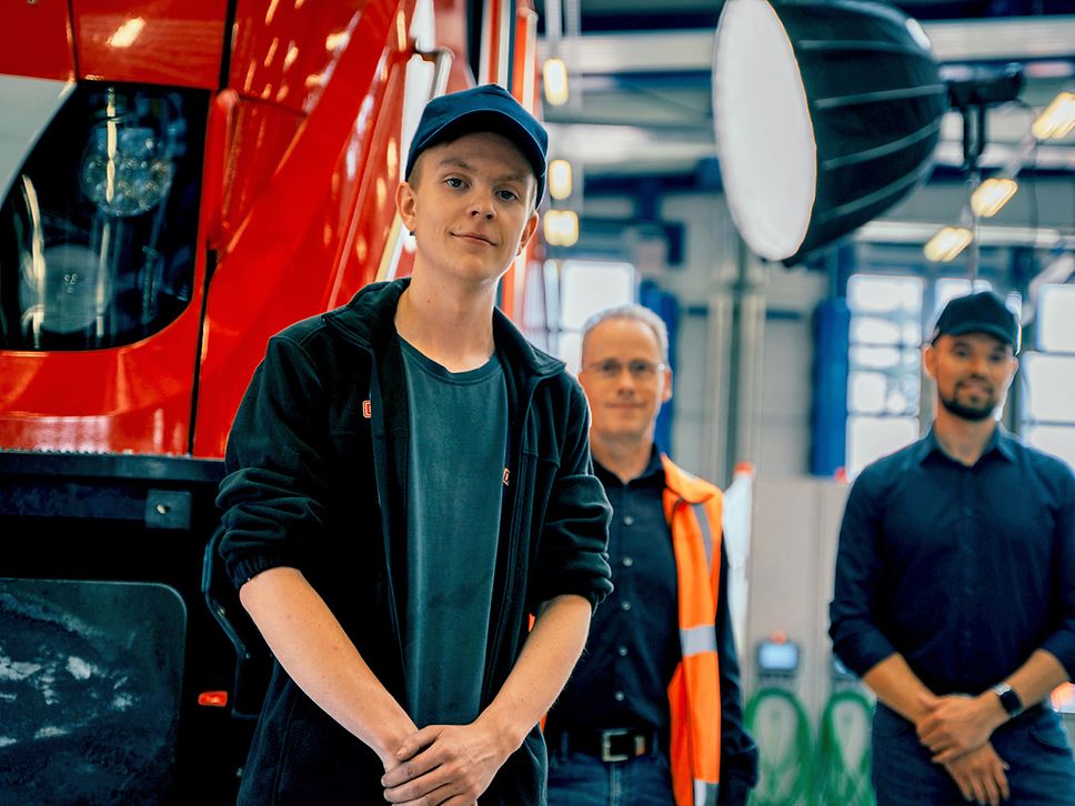 Facharbeiter in Arbeitskleidung steht vor der Lok und schaut in die Kamera