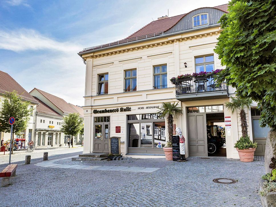 Außenansicht eines Gasthauses mit Palmen davor.