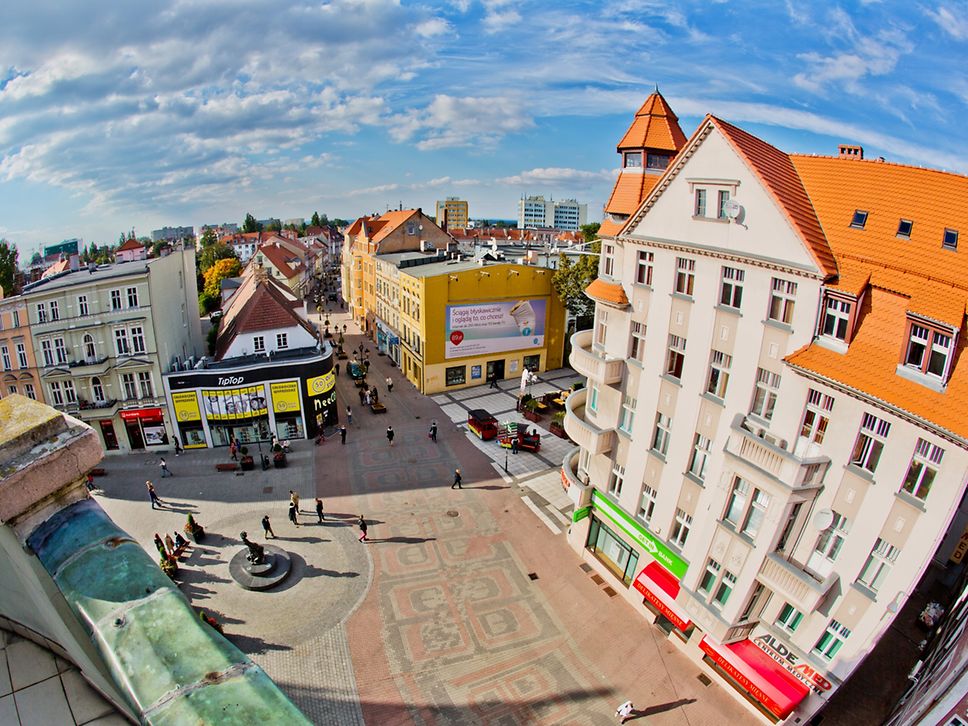 Eine Luftaufnahme zeigt einen belebten Platz in Zielona Góra an einem sonnigen Tag mit Schleierwolken am Himmel.