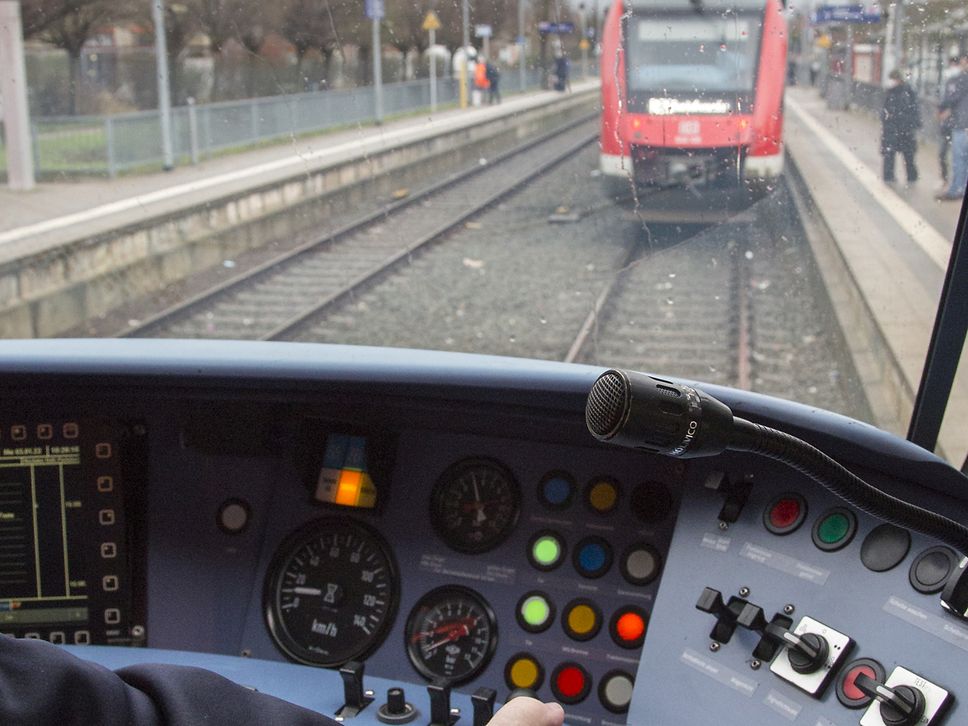 Blick aus dem Führerstand eines Zuges auf die Schienen, während der Einfahrt in einen Bahnhof.