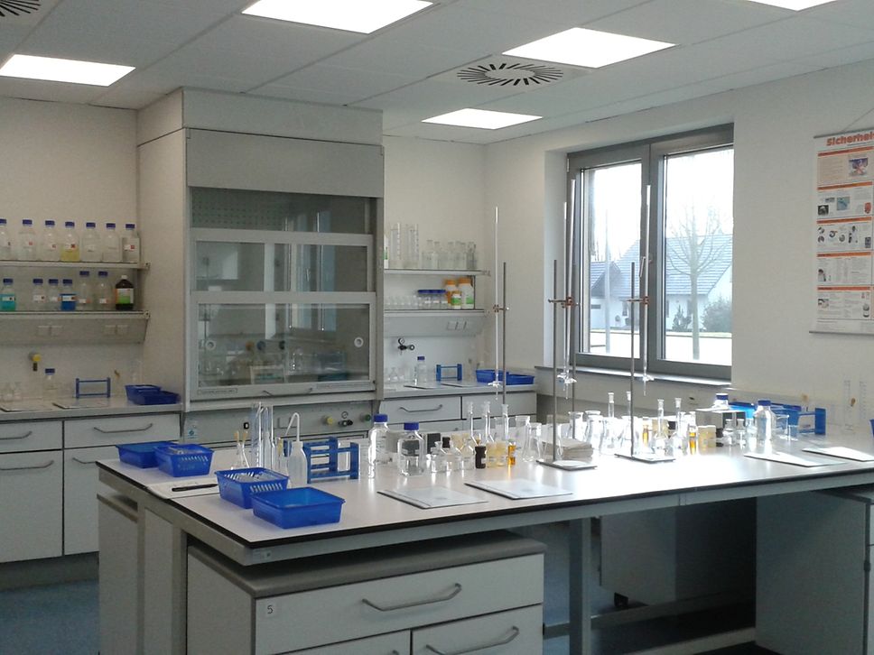 Ein Laborraum mit einem Arbeitstisch in der Mitte, auf dem alles für Experimente vorbereitet ist.