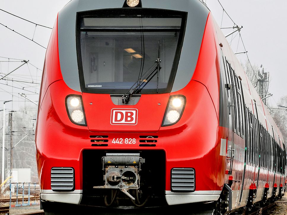 Frontalansicht einer roten Regionalbahn auf der Strecke.