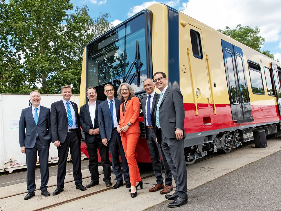 Sieben Personen stehen vor dem ersten montierten neuen S-Bahnzug