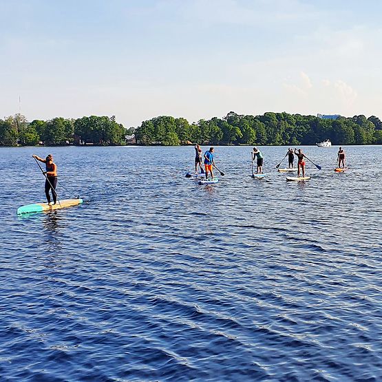 Menschen auf SUP-Boards auf dem Wasser.