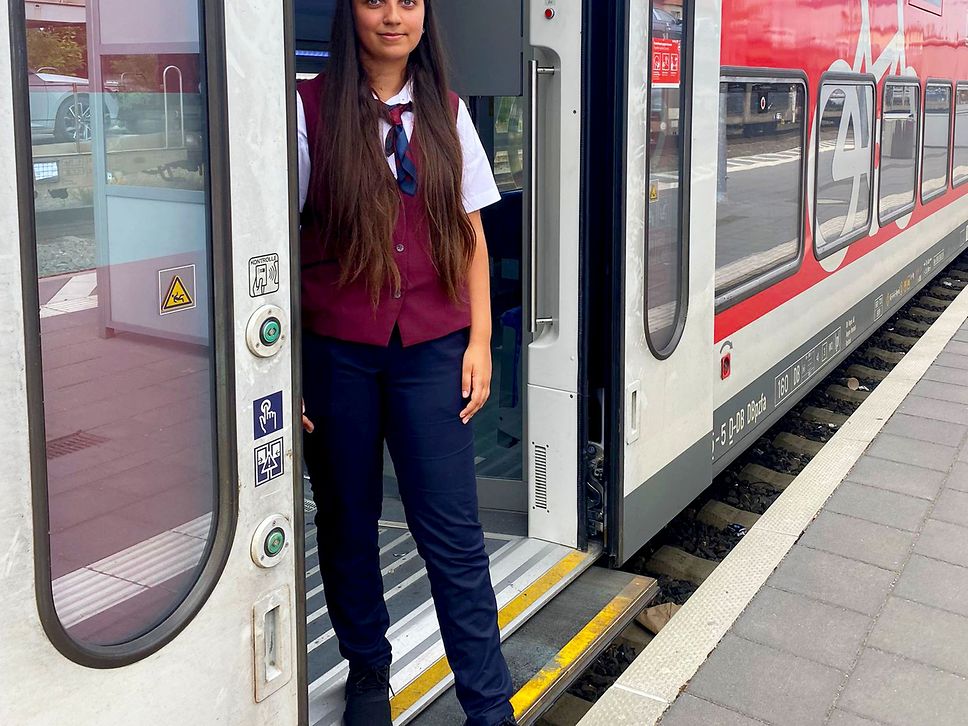 Azubine Amina Ali steht in der Zugtür eines Regionalzuges.