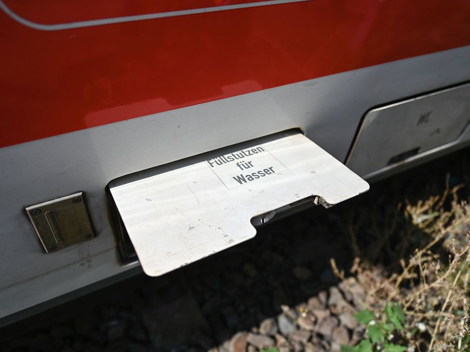 Eine graue Klappe an einem Zug ist aufgeklappt, darauf die Schrift: Füllstutzen für Wasser.