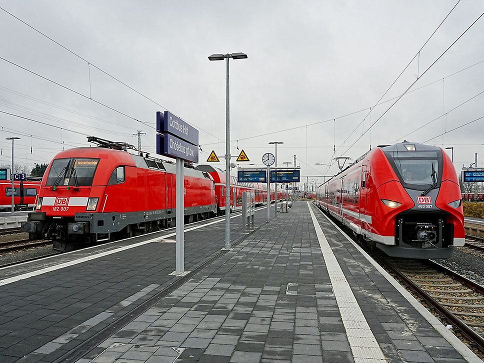 Zwei rote Regionalzüge stehen am Gleis in Cottbus.
